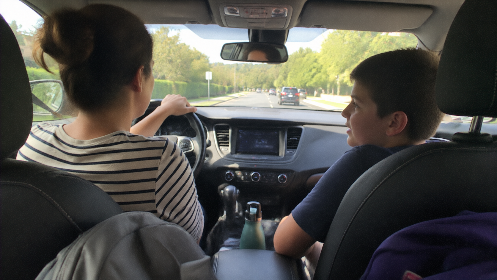 A mother talking with her teenage son during a car ride, reflecting how to get your teen son to open up.