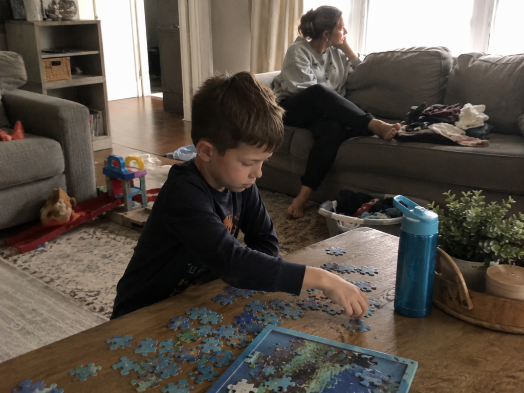 A child working independently while his mother gives him space to become a cooperative learner.