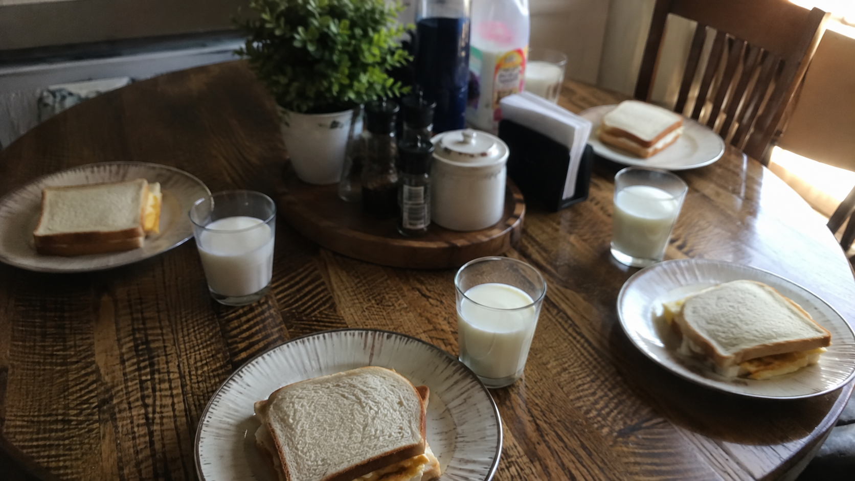 A family breakfast table with four plates and four cups of milk amid pressure to have another baby.
