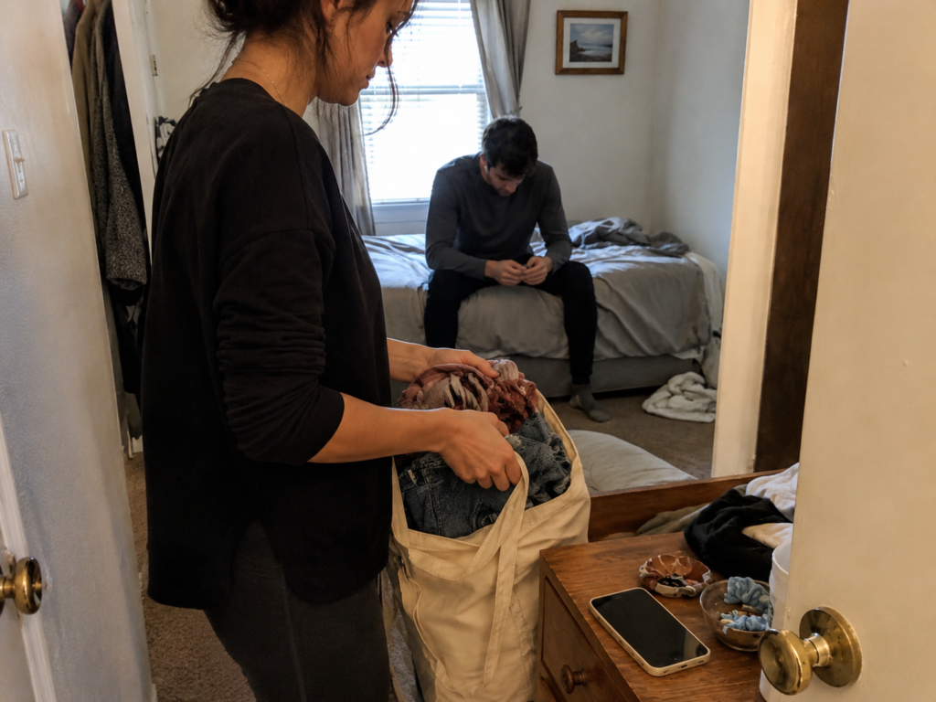A woman gathering her belongings while leaving a relationship during a difficult financial period.