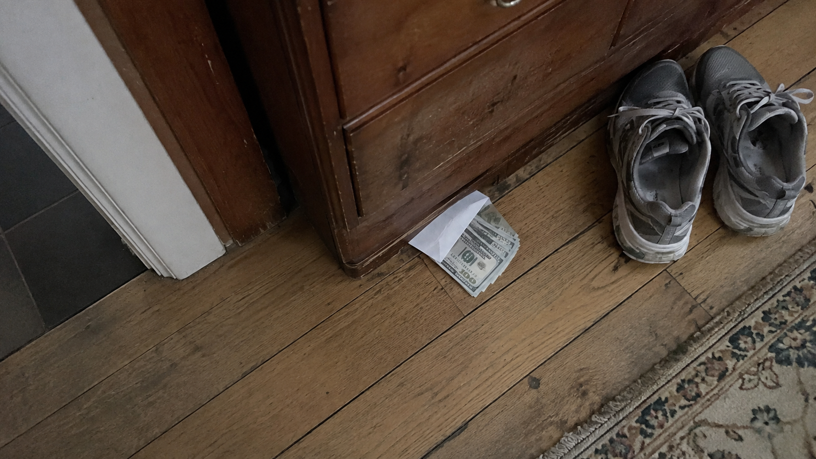 Cash envelope under a shoe cabinet representing relationship red flags and broken trust.