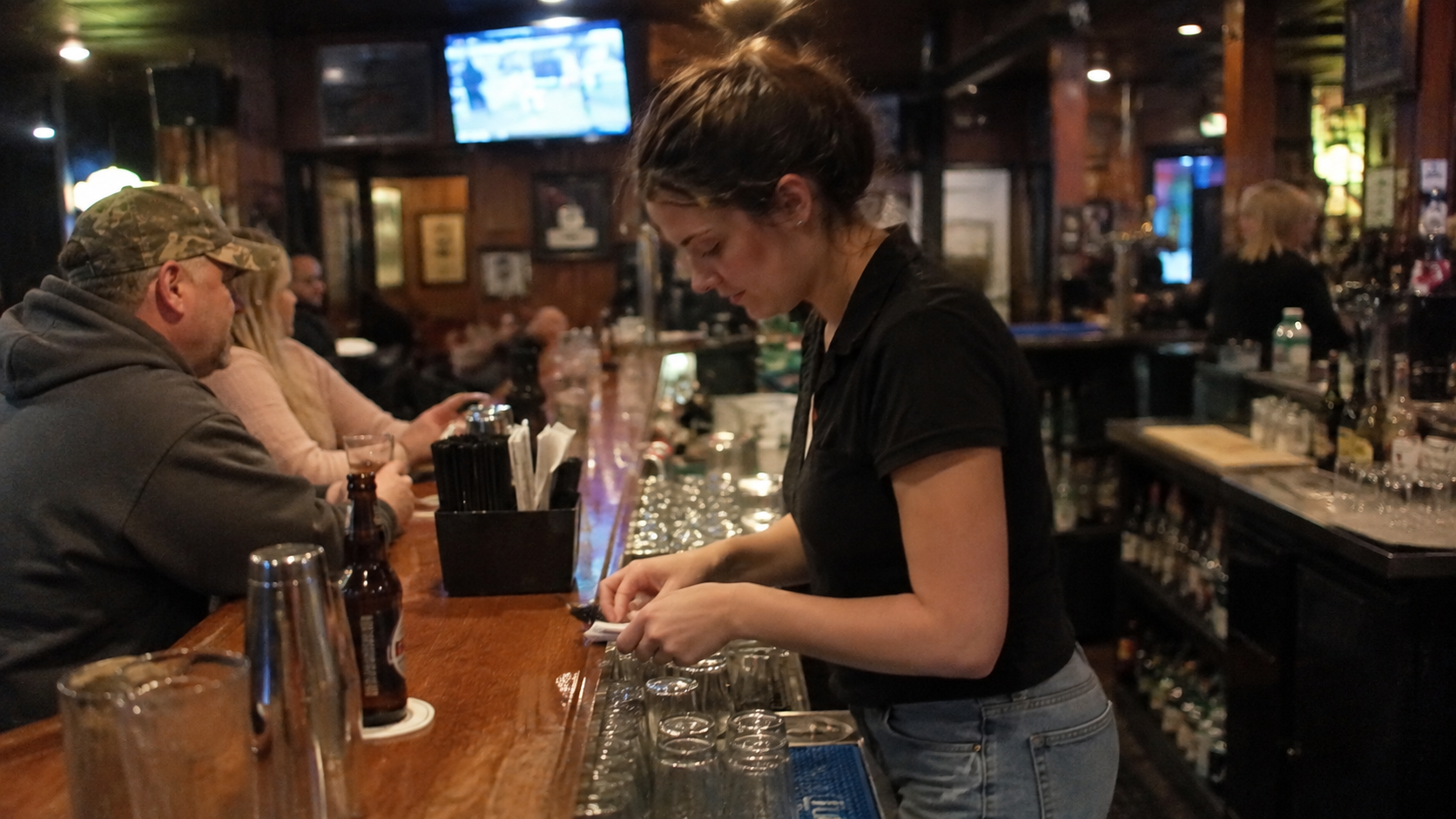A young woman working a restaurant shift while facing toxic parents financial abuse.